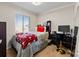 Cozy bedroom featuring a comfortable bed, window with blinds, and functional desk area at 3155 Kedleston Ave, Highlands Ranch, CO 80126