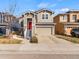 Charming two-story home featuring a red front door, attached garage, and stone accents at 3155 Kedleston Ave, Highlands Ranch, CO 80126