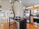 Open kitchen boasts modern appliances, eat-in table with stools, wooden cabinets, and lots of light at 3155 Kedleston Ave, Highlands Ranch, CO 80126