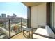 Relax on this balcony with a chair and end table, offering city views and glass railings at 1750 Wewatta St # 834, Denver, CO 80202