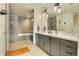 Modern bathroom featuring double sinks, a glass-enclosed shower, and stylish lighting fixtures at 1750 Wewatta St # 834, Denver, CO 80202