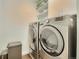 Well-organized laundry room with front load washer and dryer and upper storage cabinets at 1750 Wewatta St # 834, Denver, CO 80202