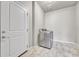 Convenient laundry room with modern washer and dryer units next to an entry door at 12444 Madison Way, Thornton, CO 80241
