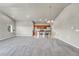 Open-concept living space with neutral carpeting, modern lighting, and seamless flow to the kitchen at 12444 Madison Way, Thornton, CO 80241