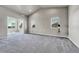 Spacious living room with modern lighting, neutral paint, plush carpeting, and large windows offering picturesque outdoor views at 12444 Madison Way, Thornton, CO 80241