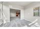 Cozy living space with natural light and new carpet leads to a modern kitchen area at 12444 Madison Way, Thornton, CO 80241