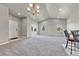 Spacious living room showcasing bar seating, a bright sunroom, and an open floor plan with seamless integration to the kitchen at 12444 Madison Way, Thornton, CO 80241
