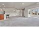 Light-filled living room with neutral paint, modern lighting, comfortable bar seating, and a view to the second living space at 12444 Madison Way, Thornton, CO 80241