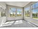 Sun-drenched living area with large windows and neutral-toned carpet offers space and natural light at 12444 Madison Way, Thornton, CO 80241