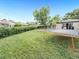 Spacious backyard featuring lush green grass, mature trees, and a trampoline for outdoor fun at 8820 Poze Blvd, Thornton, CO 80229