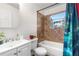 Bathroom with a shower and tub, tiled walls, white vanity, and a window offering natural light and ventilation at 8820 Poze Blvd, Thornton, CO 80229