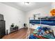 This bedroom features white walls, wood floors, bunkbeds, and a window to create a simple yet cozy living space at 8820 Poze Blvd, Thornton, CO 80229