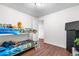 Bedroom featuring a bunk bed, dark wood floors, white walls, a dresser, and a window, offering ample space at 8820 Poze Blvd, Thornton, CO 80229