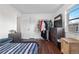 Bright bedroom featuring wood floors, a window AC unit, closet, and modern furnishings for a comfortable living space at 8820 Poze Blvd, Thornton, CO 80229