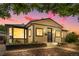 Charming bungalow with neutral siding, black trim, and a meticulously landscaped front yard under a beautiful sunset at 8820 Poze Blvd, Thornton, CO 80229