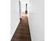Hallway with hardwood floors leading to living area with a fireplace at 8820 Poze Blvd, Thornton, CO 80229
