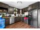Galley kitchen with wood floor, stainless steel appliances, stylish cabinets, and granite counters at 8820 Poze Blvd, Thornton, CO 80229