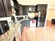 Modern kitchen features black cabinetry, stainless steel appliances, granite countertops, and wood-look floors at 8820 Poze Blvd, Thornton, CO 80229