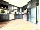 Modern kitchen features black cabinetry, stainless steel appliances, granite countertops, and wood-look floors at 8820 Poze Blvd, Thornton, CO 80229