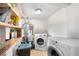 Functional laundry room features a washer, dryer, water heater, tiled floors, and storage shelves for convenience at 8820 Poze Blvd, Thornton, CO 80229