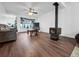 Open-concept living room with a fireplace, hardwood floors, and bright window overlooking greenery at 8820 Poze Blvd, Thornton, CO 80229