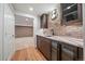 Finished basement bar area features brick wall, wooden cabinets, wine fridge and granite countertops at 2461 Spruce St, Denver, CO 80238