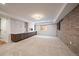 Finished basement featuring a brick wall, neutral carpet, and an accent wall with a faux fireplace at 2461 Spruce St, Denver, CO 80238