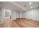 Spacious basement layout with hardwood floors leading to bar with brick wall and carpeted room at 2461 Spruce St, Denver, CO 80238