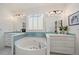 Clean bathroom features a tub with tile surround, dual sinks, and ample natural light from a window at 2461 Spruce St, Denver, CO 80238