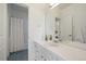 Bright bathroom featuring a single sink vanity, white cabinets, and mosaic tile flooring at 2461 Spruce St, Denver, CO 80238