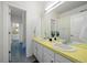 Bright bathroom featuring double sinks, white cabinets, mosaic tile flooring, and a large mirror at 2461 Spruce St, Denver, CO 80238
