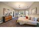Sunlit bedroom with bay windows, neutral tones, and stylish furnishings enhance comfort and appeal at 2461 Spruce St, Denver, CO 80238