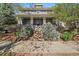 Inviting two-story home featuring a charming front porch and well-maintained landscaping at 2461 Spruce St, Denver, CO 80238