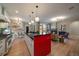 Open concept kitchen with stainless appliances, red island, and seamless flow into the living space at 2461 Spruce St, Denver, CO 80238
