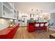 Modern kitchen with stainless steel appliances, red and white cabinets, and breakfast bar seating at 2461 Spruce St, Denver, CO 80238