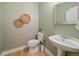 Inviting powder room features wood floors, pedestal sink, and tasteful decor; combines style with functionality at 2461 Spruce St, Denver, CO 80238