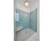 Glass enclosed shower featuring blue tiles and white tile floor; a modern, spa-like experience at 2461 Spruce St, Denver, CO 80238