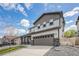 Two-story home featuring a two-car garage, stone accents, and covered porch at 10506 Akron St, Commerce City, CO 80640