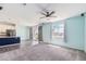Bright living room featuring a ceiling fan, carpet, and access to the patio at 10506 Akron St, Commerce City, CO 80640