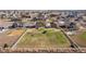 Aerial view of a home with a large backyard, playground, and white fencing in a residential neighborhood at 11343 E 163Rd Ct, Brighton, CO 80602