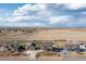 Aerial view showcasing a home with a detached garage, large backyard, and surrounding neighborhood at 11343 E 163Rd Ct, Brighton, CO 80602