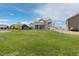 Well-maintained backyard with lush green grass, a white fence, and a covered patio at 11343 E 163Rd Ct, Brighton, CO 80602