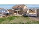 Expansive backyard featuring a covered patio with seating, a lush lawn, and white fencing at 11343 E 163Rd Ct, Brighton, CO 80602