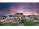 Spacious backyard with a play set, trampoline, green grass, and a picturesque sunset in the sky at 11343 E 163Rd Ct, Brighton, CO 80602