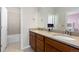Bathroom with double granite sinks and wooden cabinets, a doorway view of the commode and bath at 11343 E 163Rd Ct, Brighton, CO 80602