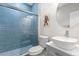 Modern bathroom with glass-enclosed shower, blue subway tile, vessel sink and patterned flooring at 11343 E 163Rd Ct, Brighton, CO 80602