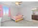 Bedroom with bright colorful decor featuring pink curtains, a ceiling fan, and an ensuite bath at 11343 E 163Rd Ct, Brighton, CO 80602