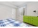 Bright bedroom featuring a side window, a door, and colorful dresser with ample storage at 11343 E 163Rd Ct, Brighton, CO 80602