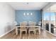 Bright dining room features modern lighting, unique wall design, and sliding glass door to the outdoors at 11343 E 163Rd Ct, Brighton, CO 80602