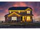 Attractive home featuring warm exterior lighting, a well-kept lawn, and decorative stone accents at 11343 E 163Rd Ct, Brighton, CO 80602